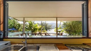 A kitchen with a large window, a sink, and a stove. - Temenino Villa Komako Seaside House (Taiarapu-Ouest)