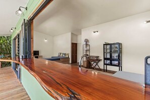 A modern interior with a wooden bar, a bed, a desk, and a cabinet. - Temenino Villa Komako Seaside House (Taiarapu-Ouest)