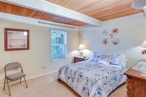 A bedroom with a bed, a chair, a window, a lamp, and wall decorations. - Serene 3BR Home in Kent With Modern Comforts (Covington)
