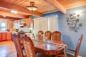 Ein Esszimmer mit Holztisch und -stühlen, einer Kristallleuchtre und einem Wanddekor.