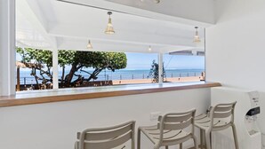 Un espace détente avec vue sur la mer, un comptoir en bois et un distributeur d’eau.