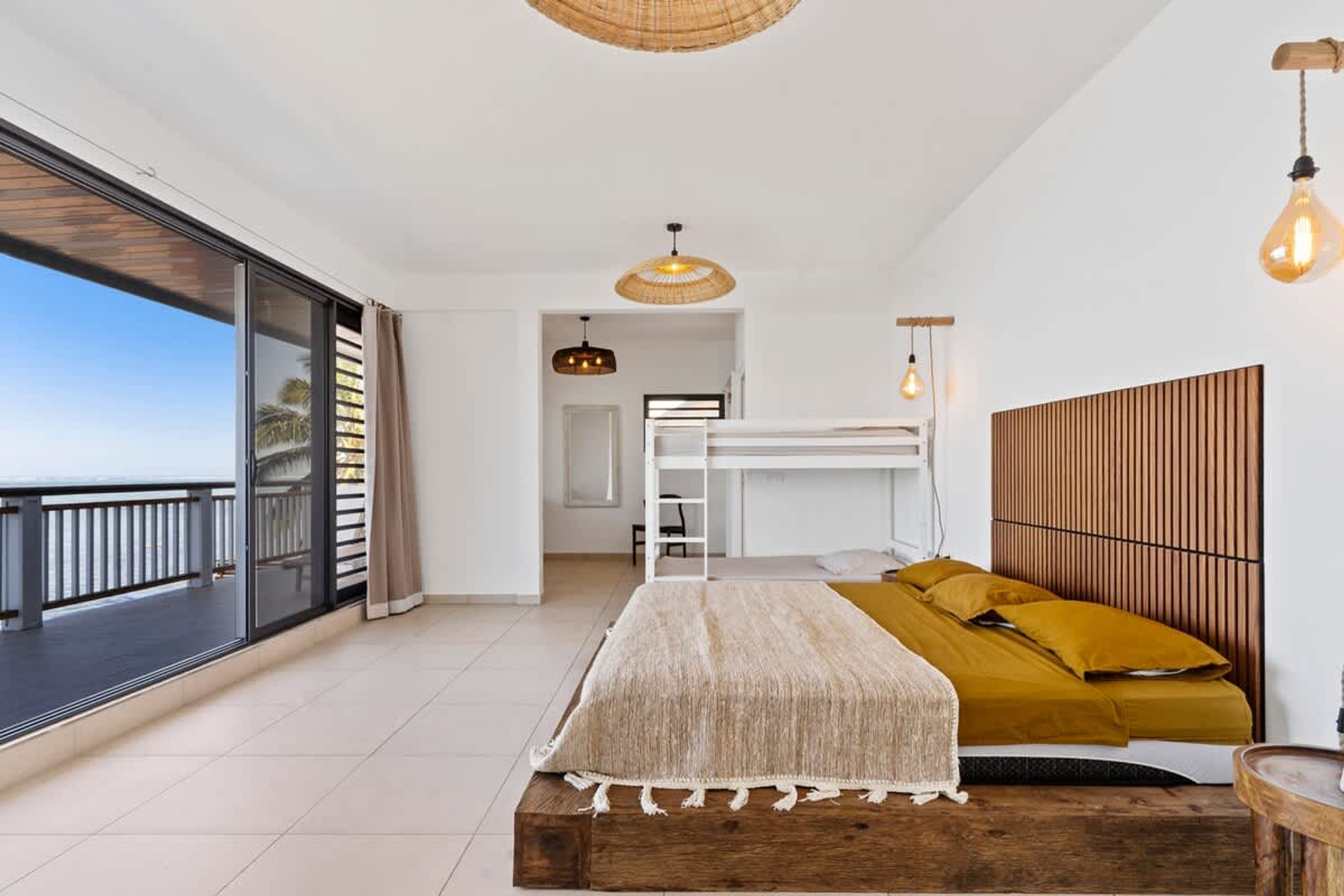 Een moderne slaapkamer met balkon, een stapelbed en een groot raam.
