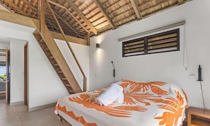 A bedroom with a bed, a window, a wall-mounted light, and a wooden staircase. - Seaside Haven Expansive 3BR Villa in Moorea (Moorea-Maiao)