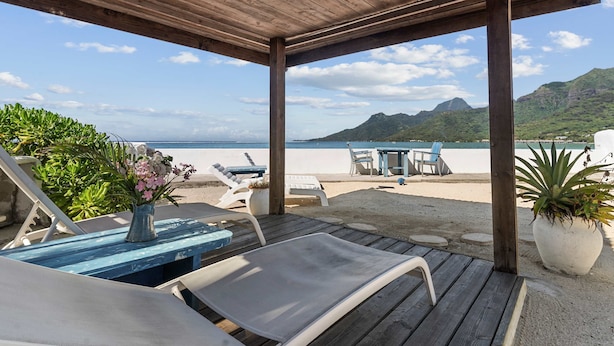 A wooden deck with lounge chairs and a table, overlooking a beach and mountains. - Seaside Air-conditioned Bungalow Tamara (Moorea-Maiao)