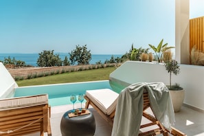 Un balcon avec une piscine, des chaises longues et une vue sur la mer.
