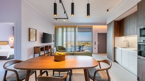 Ett modernt hotellrum med en matplats, en TV, en soffa och utsikt över staden.