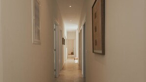 A hallway with doors on both sides, a framed picture on the right wall, and a light fixture on the ceiling. - FR Villa Mulberry in Sivota (Lefkada)