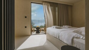 Ein modernes Schlafzimmer mit großem Fenster, einem Bett, einem kleinen Tisch und einem Stuhl.