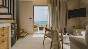 A modern interior with a kitchen, dining area, and a view of the sea. - Orizontas 3 Syvota in Igoumenitsa (Igoumenitsa)