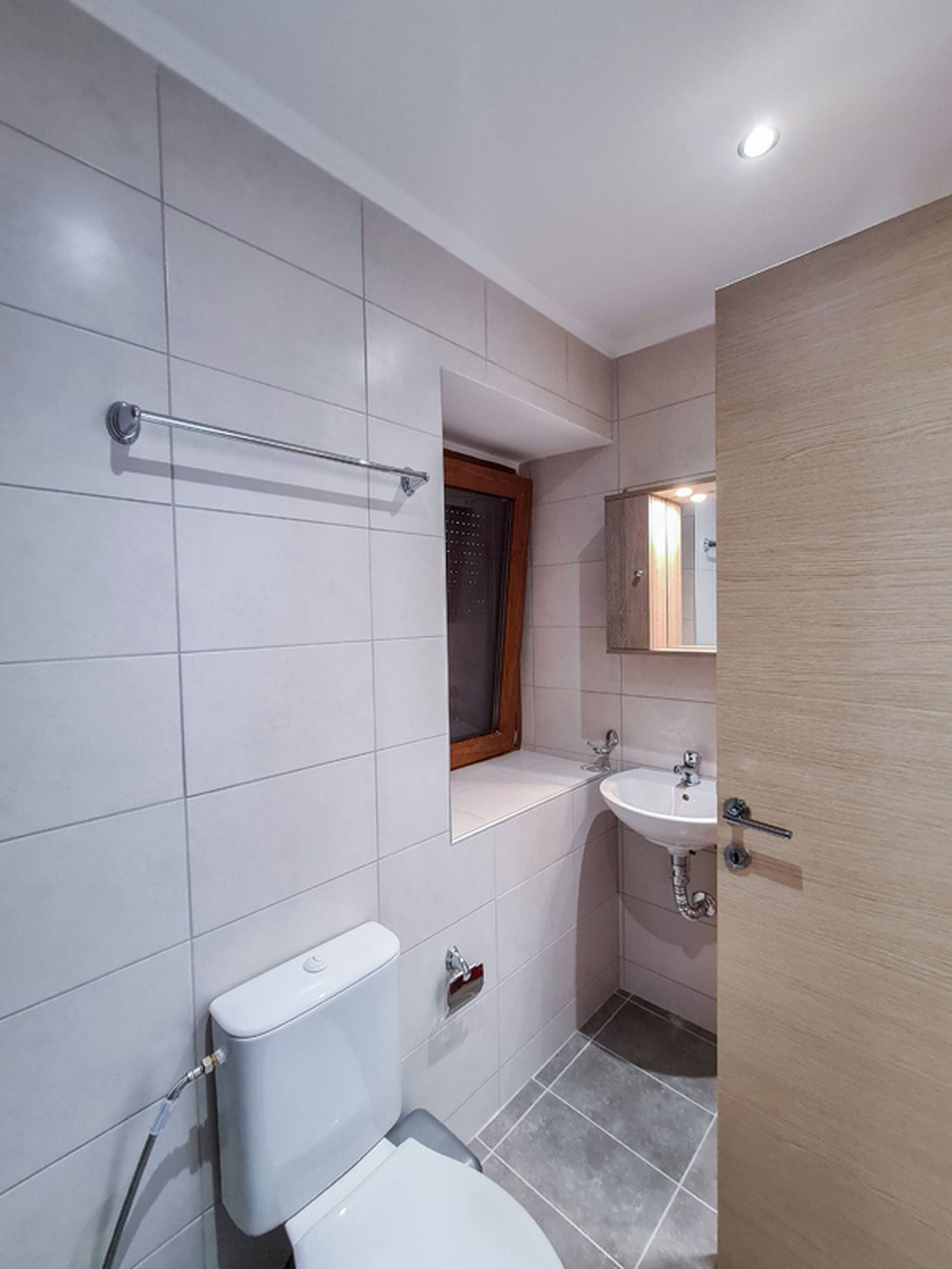 Une salle de bain avec des toilettes, un lavabo et une douche.