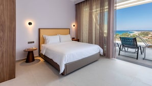 Een moderne hotelkamer met een groot bed, een klein nachtkastje, een stoel en uitzicht op zee.