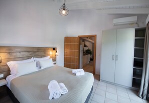 Ein Schlafzimmer mit einem Bett, Nachttischlampen, einem Kleiderschrank und einer Klimaanlage.