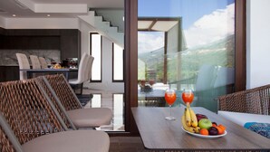 Une chambre d’hôtel moderne dotée d’un balcon, d’un coin repas et offrant une vue sur l’extérieur.