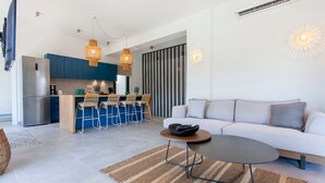 Ein modernes Wohnzimmer mit einer Couch, einem Couchtisch und einer Küchenzeile mit Esstisch.