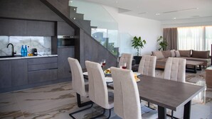 A modern interior with a dining area, kitchen, staircase, and living space. - Zavia Villa ENA 2B Syvota (Igoumenitsa)
