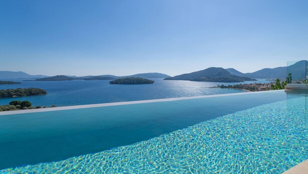 A pool with clear blue water, surrounded by a mountainous landscape and islands. - Smirties Villa Pasithea 4bed (Lefkada)