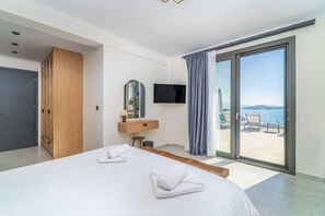 A hotel room with a bed, a TV, a wooden wardrobe, a bathroom, and a balcony with a view. - Smirties Villa Pasithea 4bed (Lefkada)
