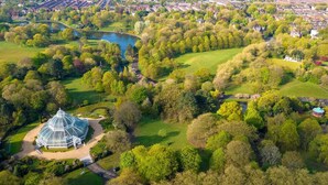 An aerial view of a park with a large glass-domed building, surrounded by lush greenery and a lake. - 3 Floors Loft 2mins to Train Patio Parking (Liverpool)