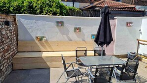 A patio with a glass table and metal chairs, a wooden bench, and a black umbrella. - 3 Floors Loft 2mins to Train Patio Parking (Liverpool)