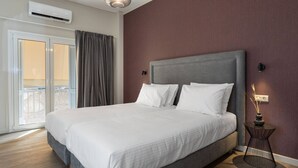 Quarto com cama, mesa de cabeceira, luminária na parede e ar condicionado.