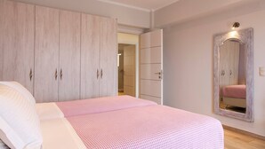 Quarto com cama, guarda-roupa e espelho.
