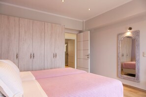 Ein Schlafzimmer mit Bett, Kleiderschrank und Spiegel.