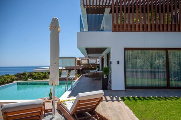 A modern house with a pool, outdoor seating, and a view of the ocean. - Zavia Villa DYO 3B Syvota (Igoumenitsa)