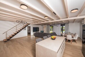 Ein zeitgemäßer Wohnraum mit Treppe, Essbereich und Küche.