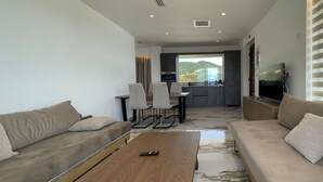 Un salon moderne avec un canapé, une table basse et un téléviseur.