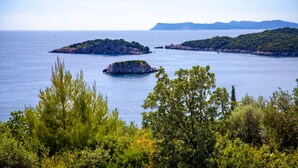 Un paysage côtier caractérisé par une mer bleue et limpide, des îles rocheuses et une végétation luxuriante.