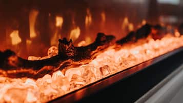 Un expositor de vidrio con cubitos de hielo y un objeto oscuro, posiblemente un adorno, en un ambiente con poca luz.