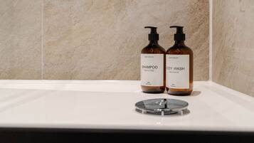 Dos botellas de jabón corporal y champú sobre una encimera de baño.