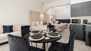 Uma sala de estar moderna com sofá, mesa de jantar e cozinha.