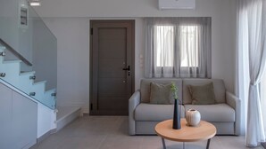 Una sala de estar moderna con un sofá, una mesa de centro y una escalera.