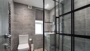 Ein modernes Badezimmer mit einer Duschkabine, einer Toilette und einem Waschbecken.