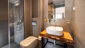 A modern bathroom with a glass-enclosed shower, a wooden vanity, and a large mirror. - Drakatos X Apartment (Lefkada)