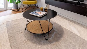 A modern living room with a large flat-screen TV, a yellow chair, a round coffee table with a magazine, a potted plant, and a sliding glass door leading to a balcony. - Beehive 1A in Athens (Athens)