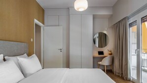 A modern hotel room with a large bed, a desk, a laptop, and a view of the outside. - Beehive 1A in Athens (Athens)