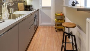 A modern kitchen with a built-in oven, a sink, and a wooden countertop. - Beehive 1A in Athens (Athens)