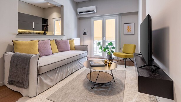 A modern living room with a sofa, a coffee table, a TV, and a chair. - Beehive 1A in Athens (Athens)