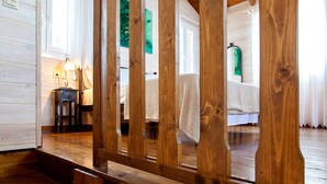 Een kamer met houten frame, een bed, nachtkastje en lamp.