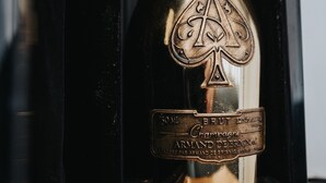 Una botella con un símbolo de pala y texto que indica que es un champán Brut de Armand De Brignac.