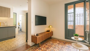 Un intérieur moderne comprenant une cuisine, une console avec une lampe, une petite table avec une plante et une grande fenêtre offrant une vue dégagée.