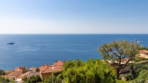 A coastal view with a boat, houses, and a large tree. - Family Villa-sea View Pool and Garden Near Monaco (Roquebrune-Cap-Martin)