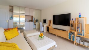 A modern hotel room with a bed, a TV, a wooden entertainment unit, and a desk with a chair. - High-end Residence With Pool and Panoramic Views (Beausoleil)