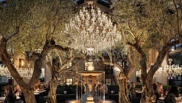 An outdoor dining area with trees, a fountain, and chandeliers. - Luxe Golf View Condo Prime Napa Location (Napa)