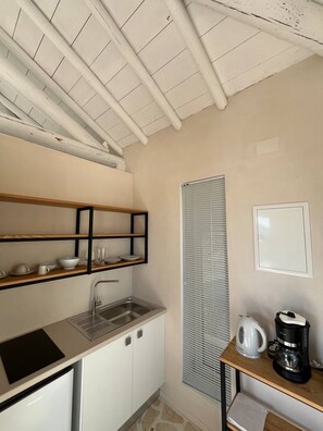 A compact kitchen with a sink, a coffee maker, and a kettle on a wooden shelf. - Pasparo Estate in Samos (Samos)