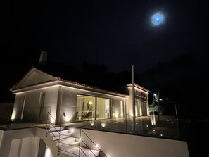 A modern house with a well-lit exterior and a visible staircase leading to the entrance. - Pasparo Estate in Samos (Samos)