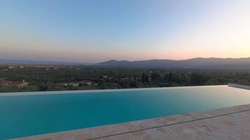 An infinity pool with a view of distant mountains and a landscape.