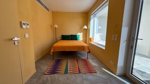 A room with a bed, a window, a door, and a thermostat on the wall. - Pasparo Estate in Samos (Samos)